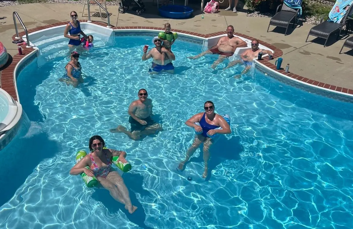 Top view of young family with daughter in pool