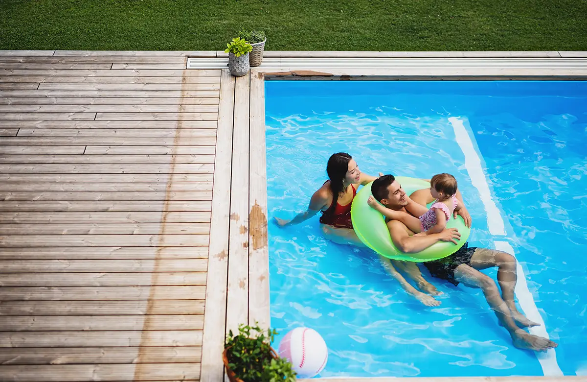 Top view of young family with daughter in pool